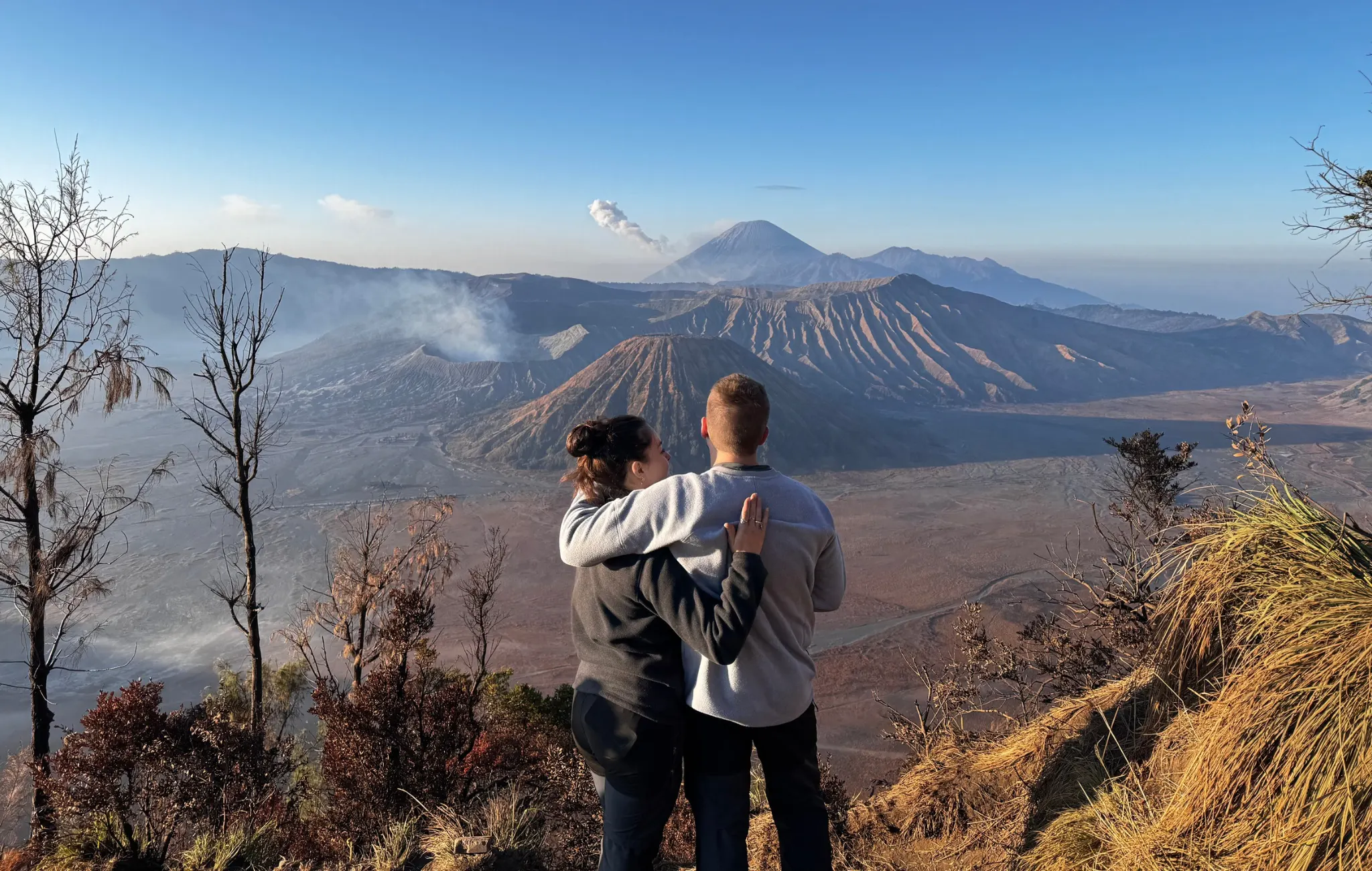 Tourists looking at Mount Bromo, Mount Batok, Mount Semeru, and caldera.